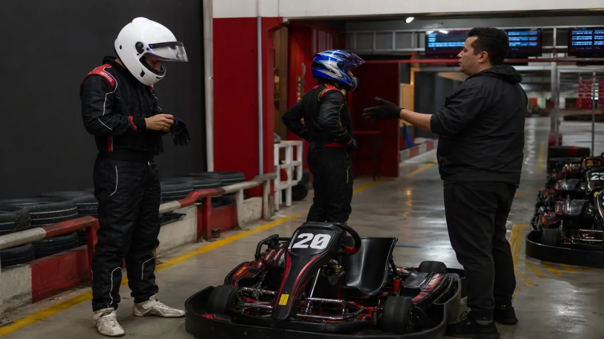 kart para universitários: Grupo de universitários em pista indoor de kart, recebendo briefing e se preparando pa.